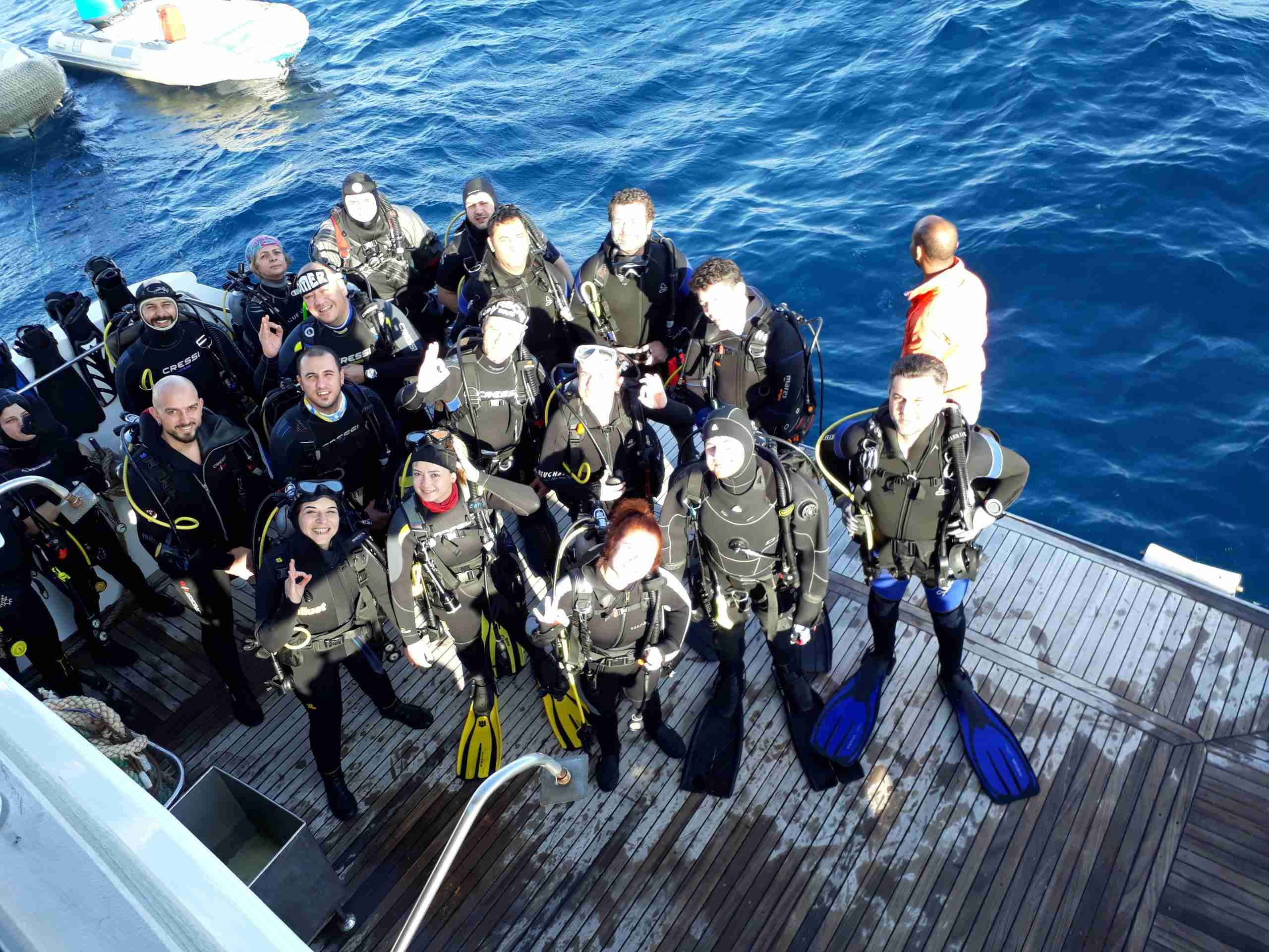 Divers in full equipment on the dive deck of a liveaboard