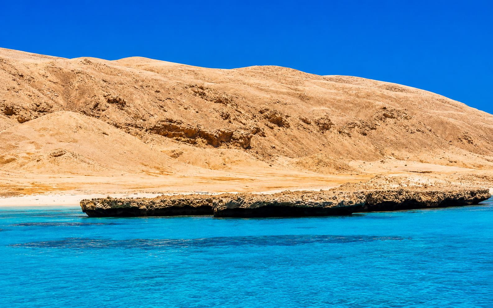 Big Giftun Island's desert coastline and clear turquoise Red Sea water near Hurghada