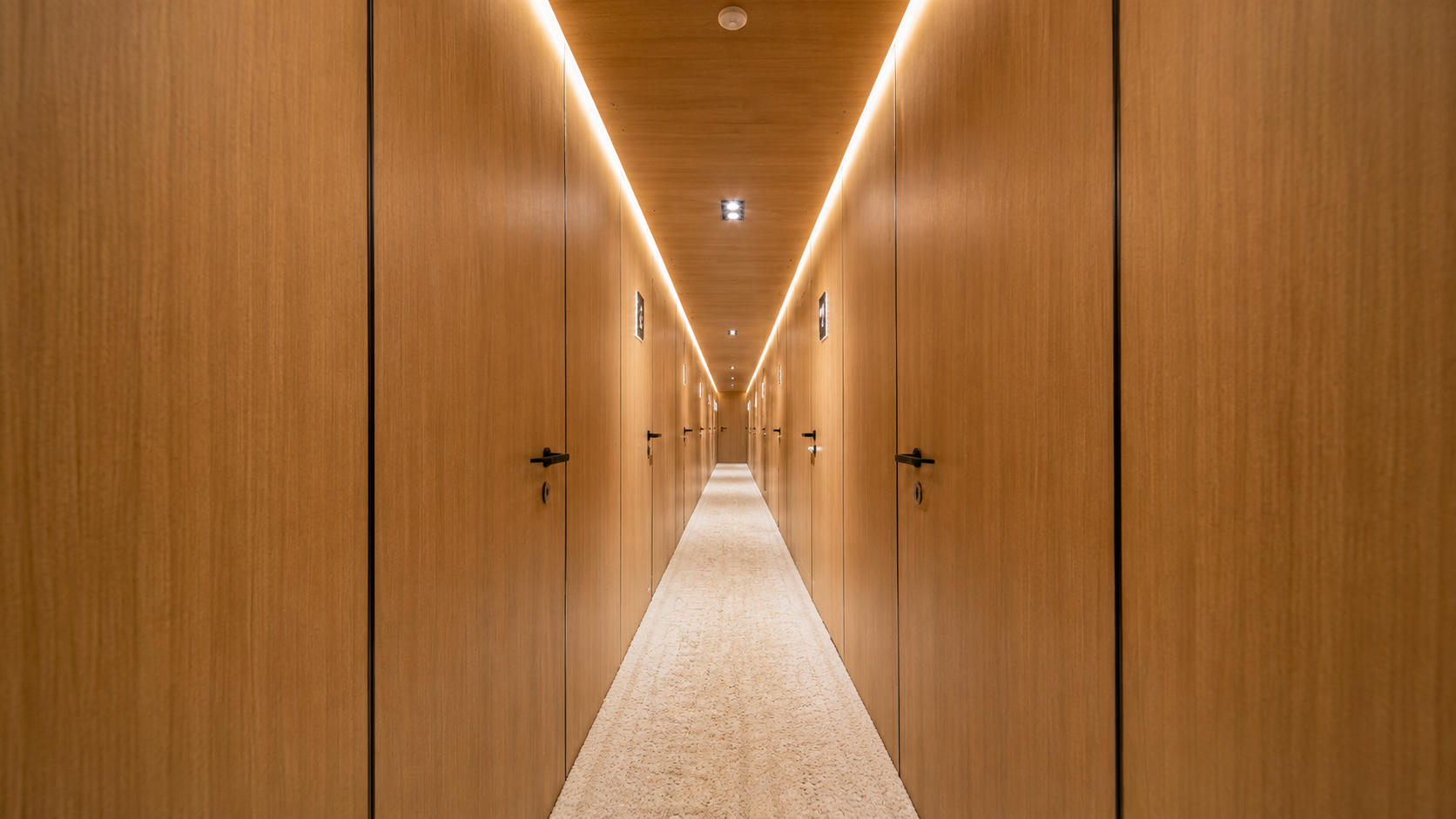 Warm wood-panelled cabin corridor below decks