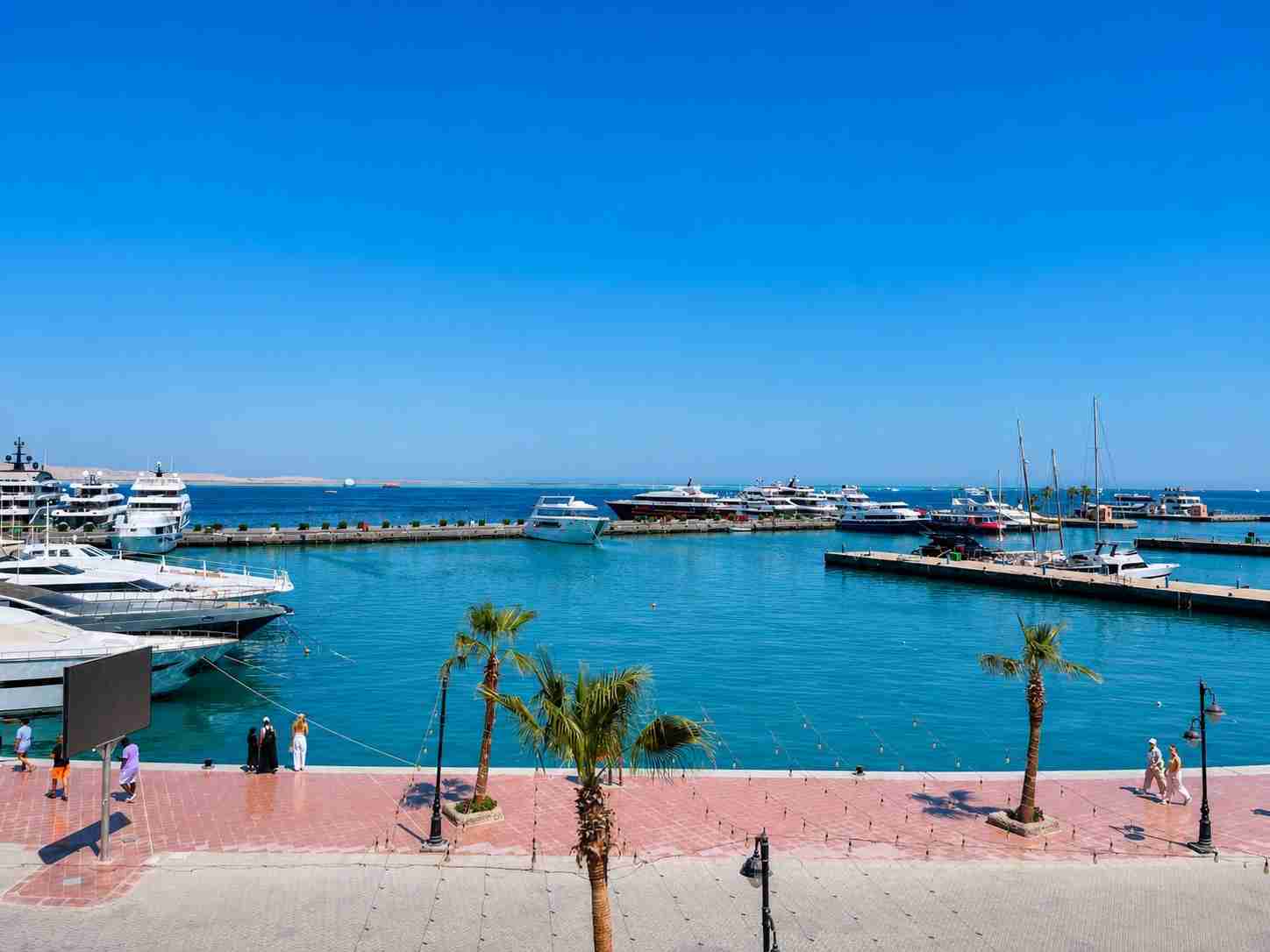 Panoramic view of Hurghada Marina on the Red Sea, Egypt, with luxury yachts, turquoise water and the waterfront promenade.