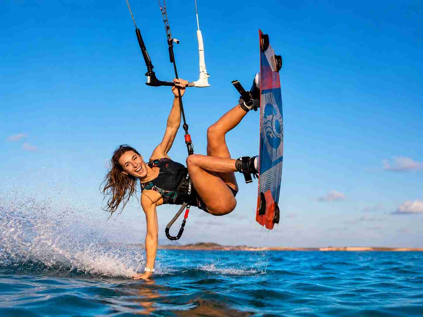 Freestyle kitesurfer performing an aerial trick over Red Sea water