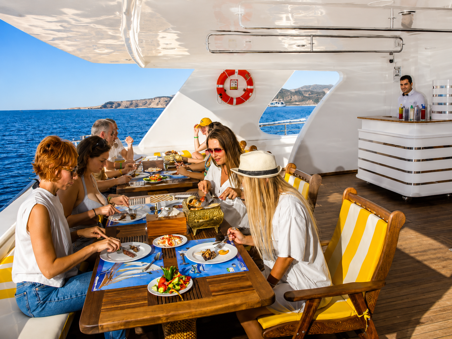 Guests enjoying lunch in the open-air dining area onboard a Red Sea boat