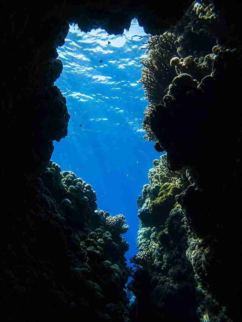 Sunlight filtering through a coral canyon and underwater passage