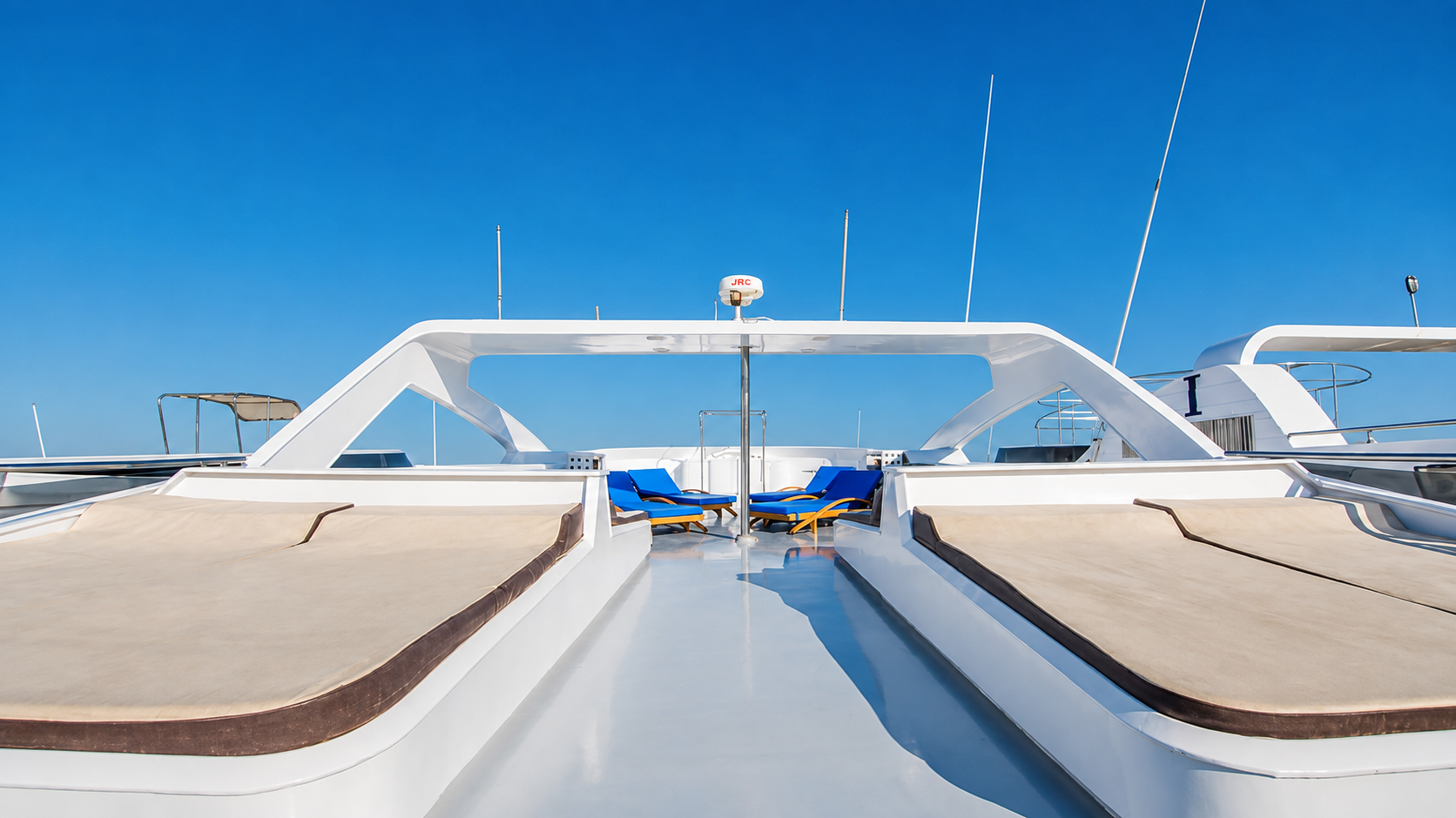 Upper sun deck with sunbathing loungers and open sea views