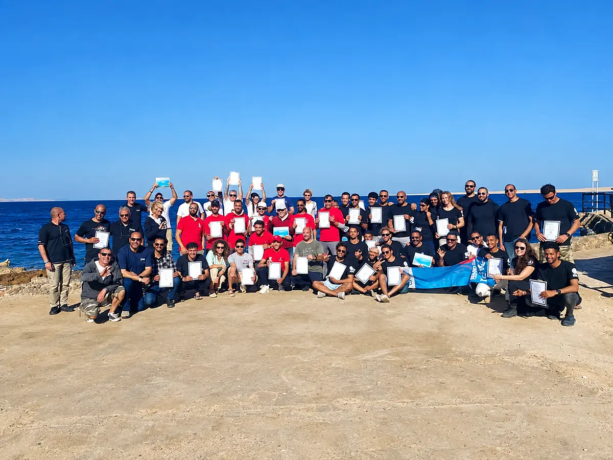Large dive team celebrating on the beach