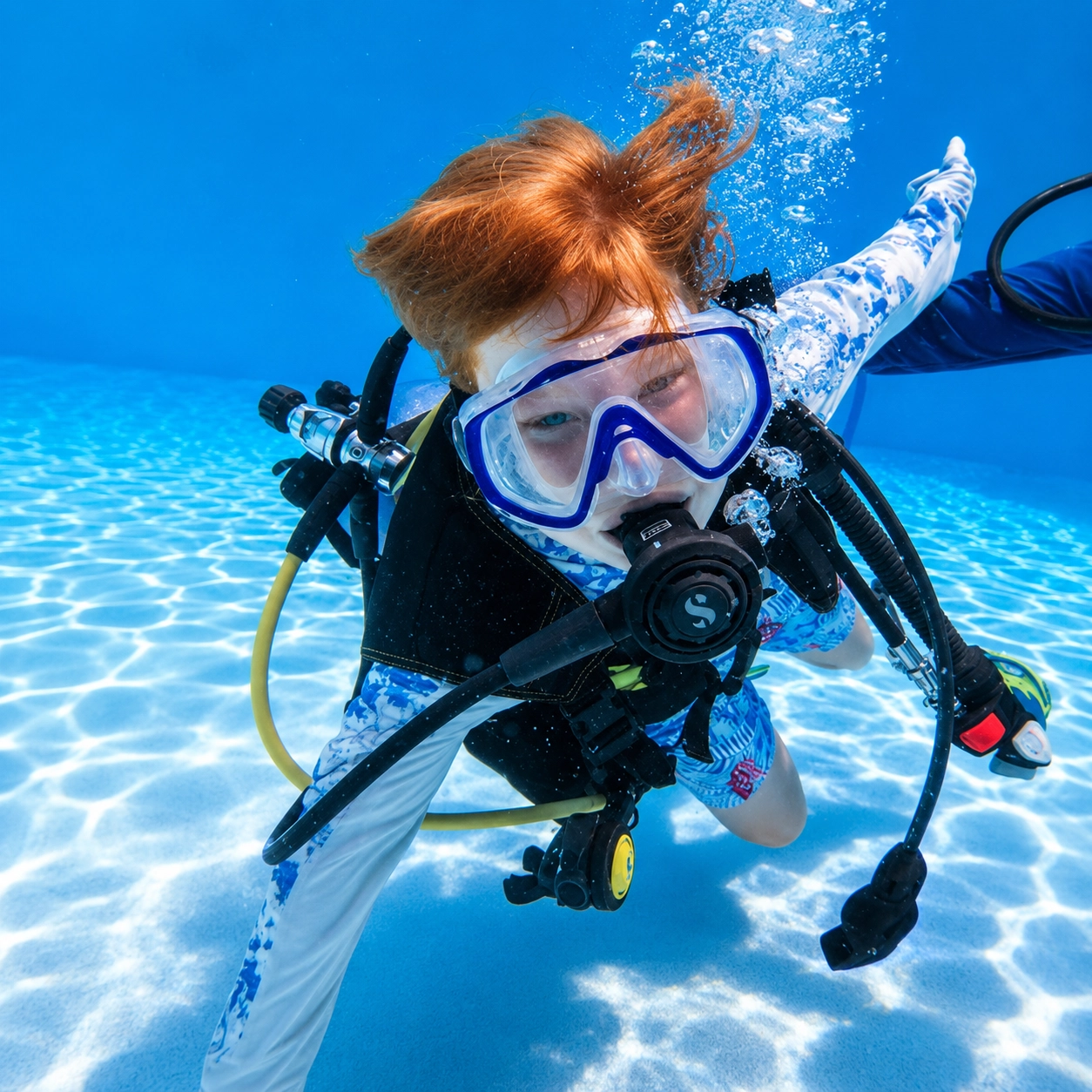 Young diver on scuba beside the instructor during PADI Bubblemaker in Hurghada