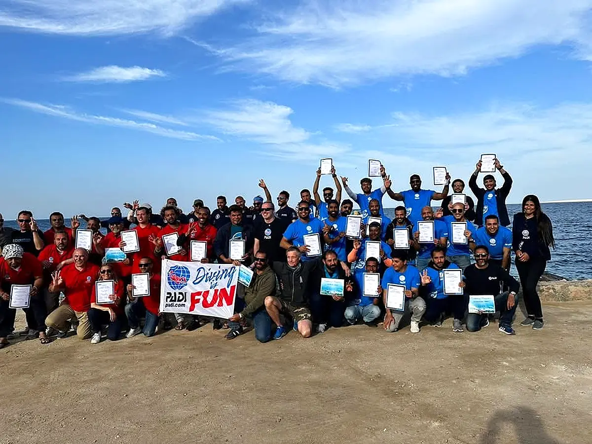 Large group celebrating certification on the beach