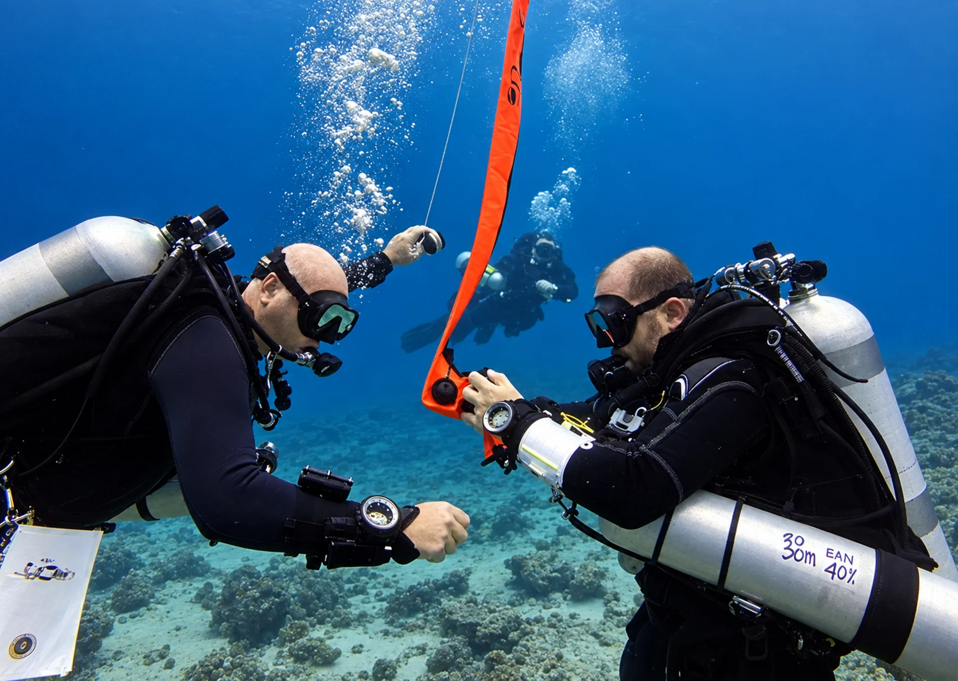 Divers deploying a surface marker buoy during technical diving training