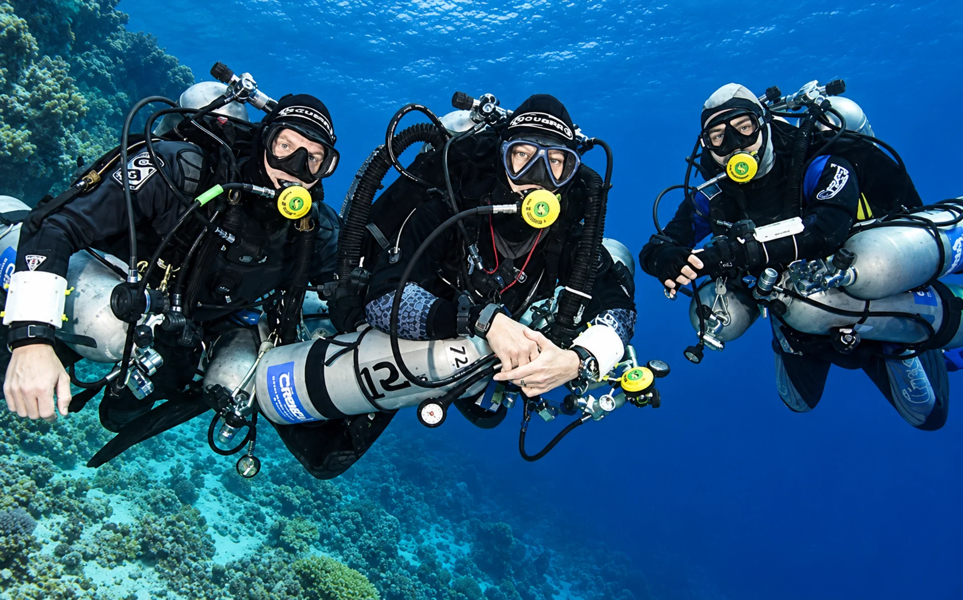 Three divers on a technical diving course exploring a Red Sea reef