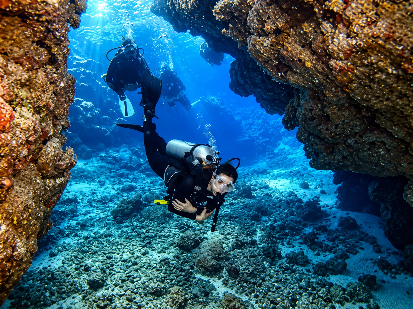 Diver dropping through a narrow reef canyon in the Red Sea
