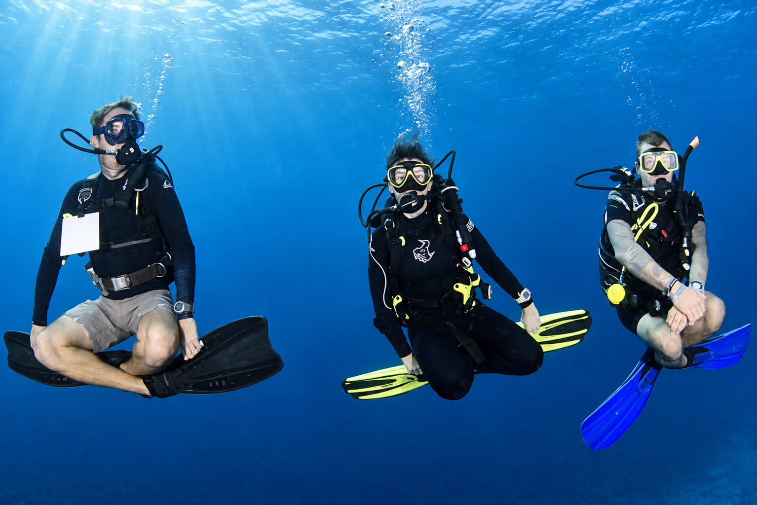 Motionless diver suspended in blue water
